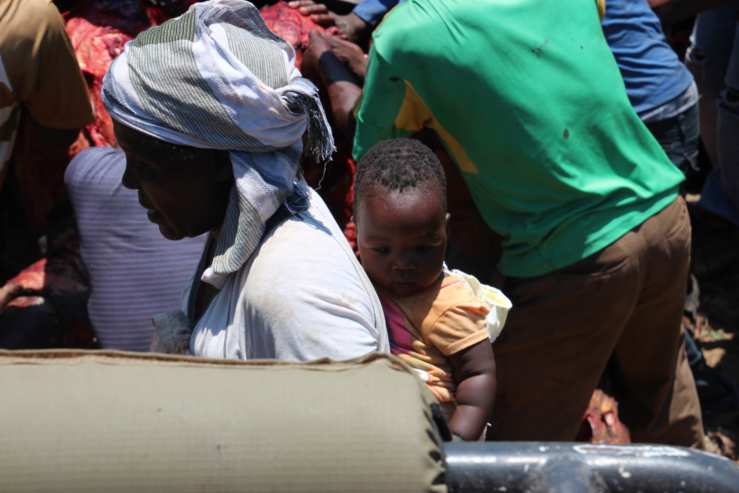 Zimbabwe woman and child wait for meat.JPG