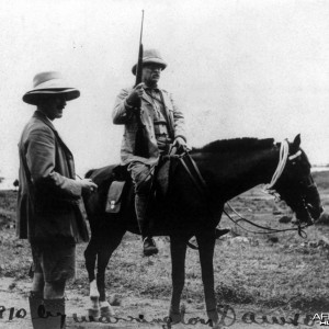 Theodore Roosevelt holding rifle on horseback in Africa, circa 1910